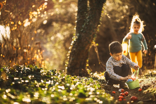 Cute little kids on Easter egg hunt in nature