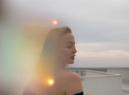 Young woman surrounded by orbs of light, embracing the March 21, 2022 weekly horoscope for her zodia...