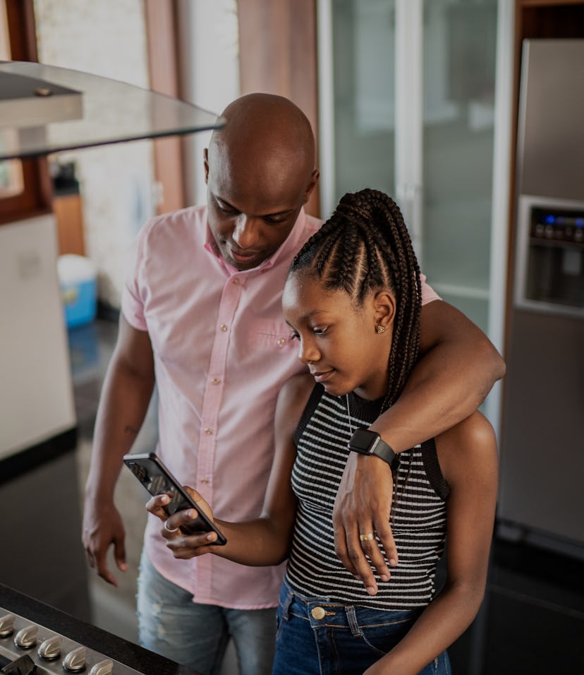 Sister showing something on smartphone to her father