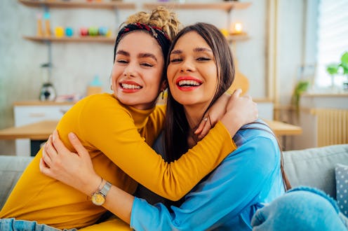 Young cheerful female friends enjoying time together at home