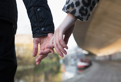 Cropped close up of affectionate young couple holding hands