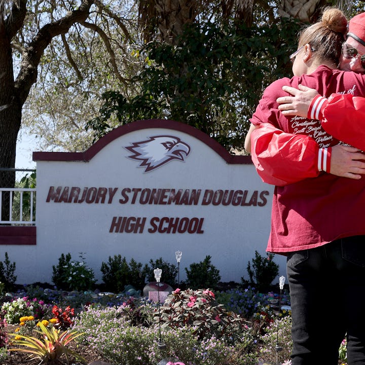 Iris Diaz hugs Mark Muniz from the Guardian Angels as she visits a memorial in front of Marjory Ston...