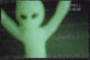green alien on film camera