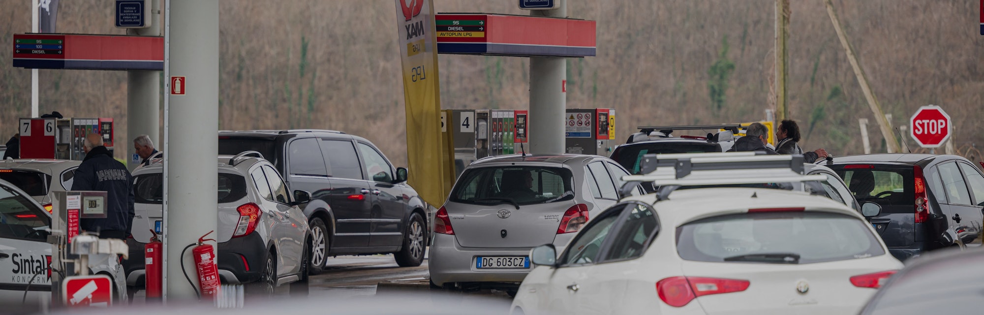 Drivers, mostly from Italy, wait in their cars to benefit from lower prices as they queue to enter t...