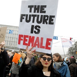 Inspiring woman holding a quote sign that says "The future is female."