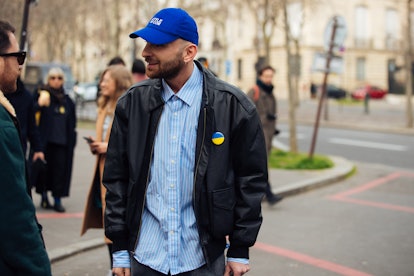 PARIS, FRANCE - MARCH 01: Beka Gvishiani of StyleNotCom wears a blue StyleNotCom cap, black leather ...