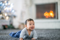 baby boy on the floor in front of a fireplace