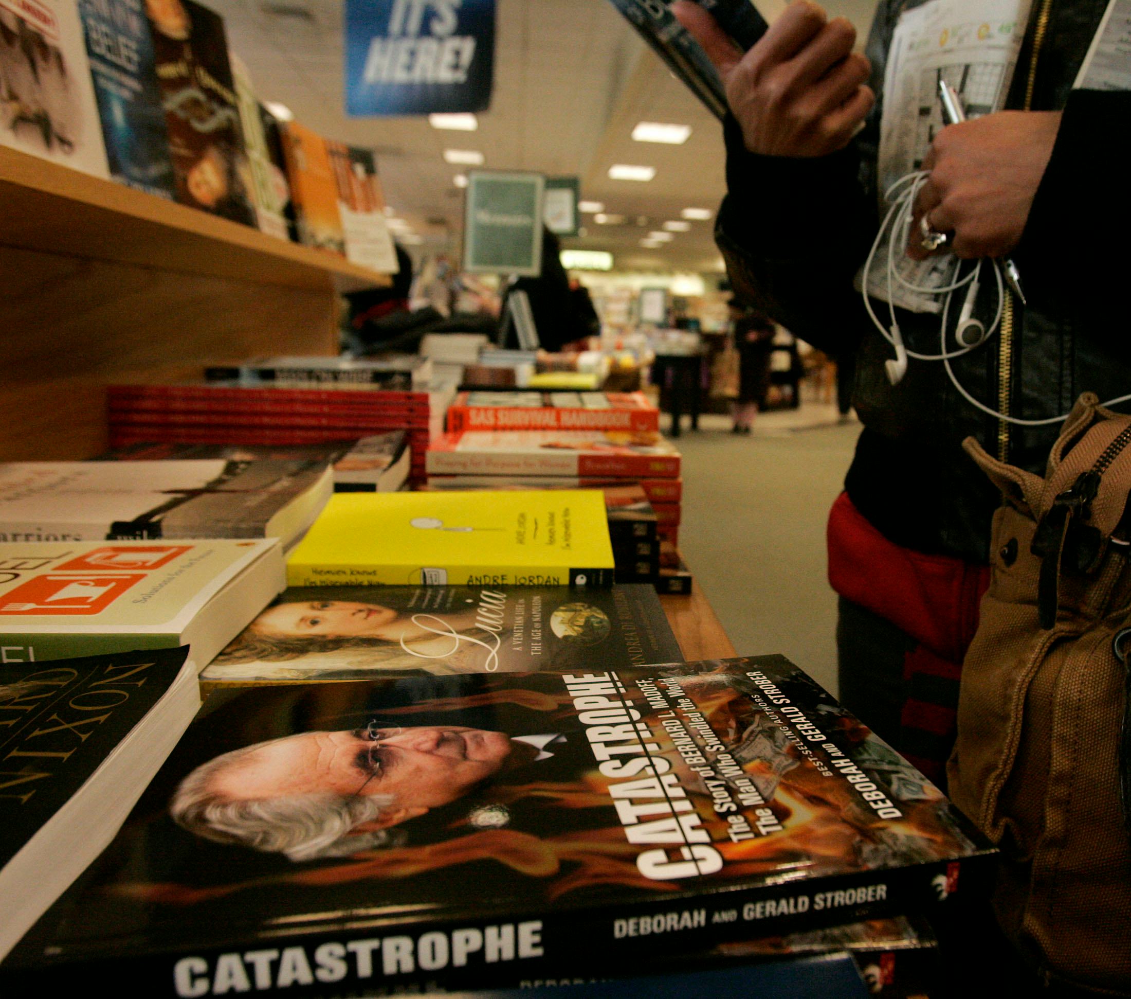 (031309 Boston, MA) A shopper looks over a book at a display table featuring copies of 'Catastrophe'...
