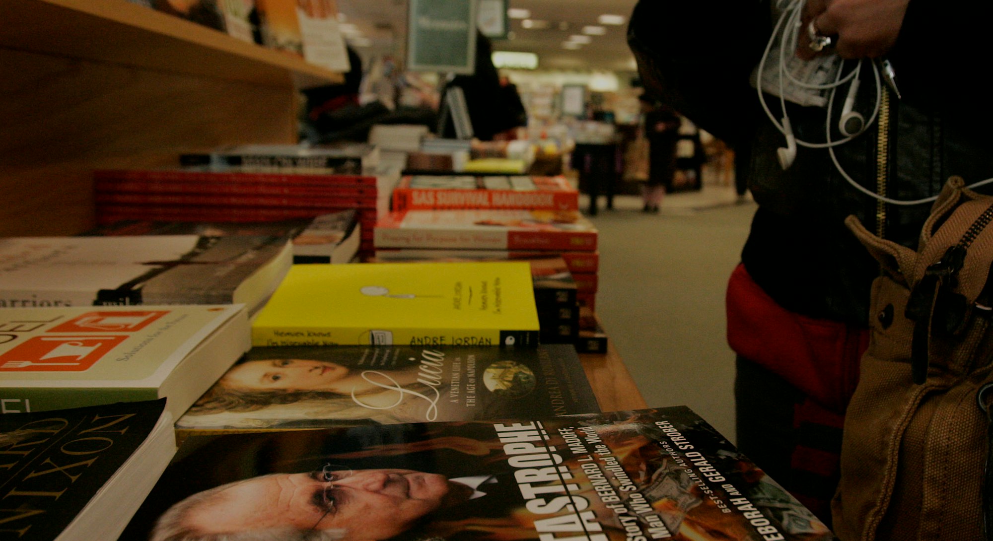 (031309 Boston, MA) A shopper looks over a book at a display table featuring copies of 'Catastrophe'...