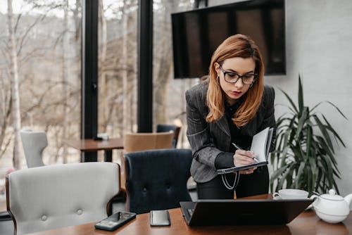 Business woman working in modern office. She is using her laptop computer for communication. Aries z...