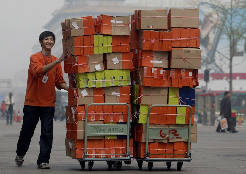 BEIJING, CHINA:  A store employee pushes carts loaded with boxes of US brand Nike sports shoes down ...