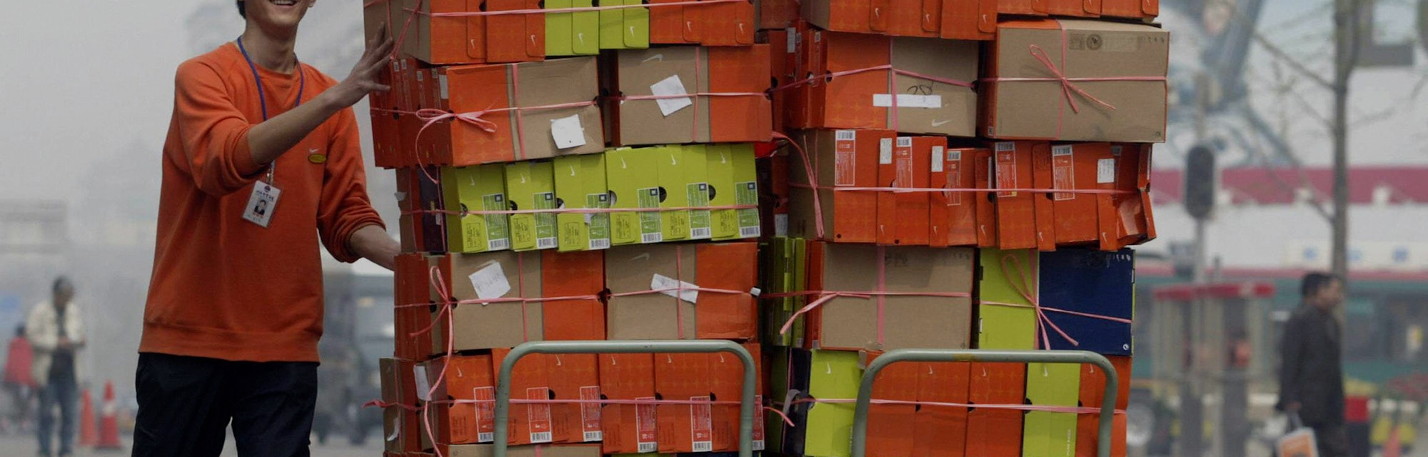 BEIJING, CHINA:  A store employee pushes carts loaded with boxes of US brand Nike sports shoes down ...