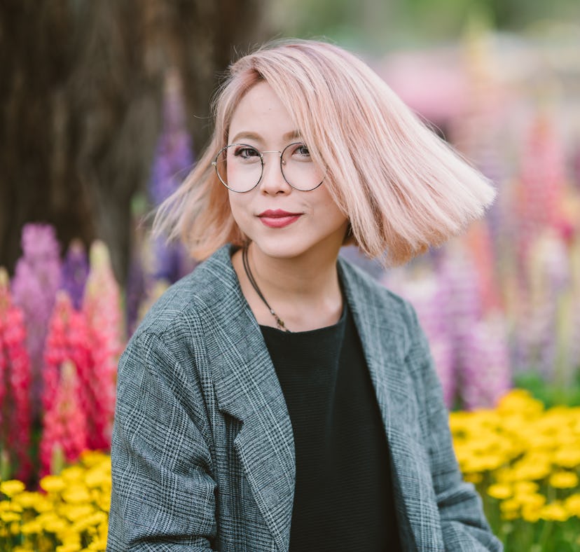 A woman with pink hair in the spring uses hair quotes for Instagram for her spring hair captions.