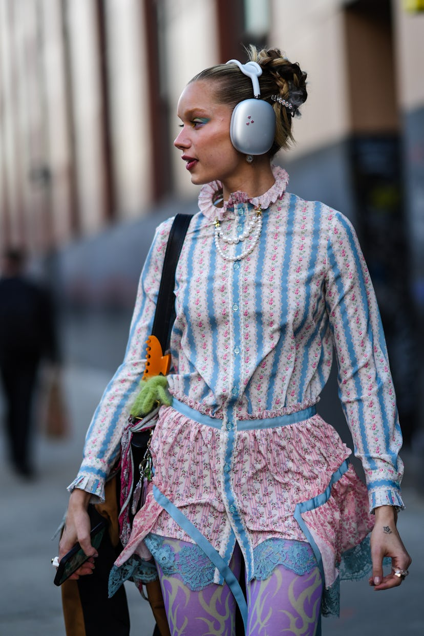 NEW YORK, NEW YORK - FEBRUARY 12: A guest wears silver headphones, a white large pearls necklace, a ...