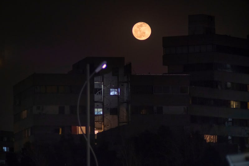 Bloody moon shines on residential complexes in the west of Tehran on the eve of Nowruz on March 19, ...