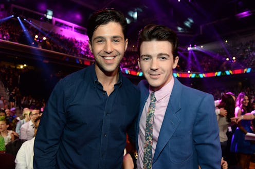 Drake Bell and Josh Peck smile and pose together in the audience at an event center. The former 'Dra...