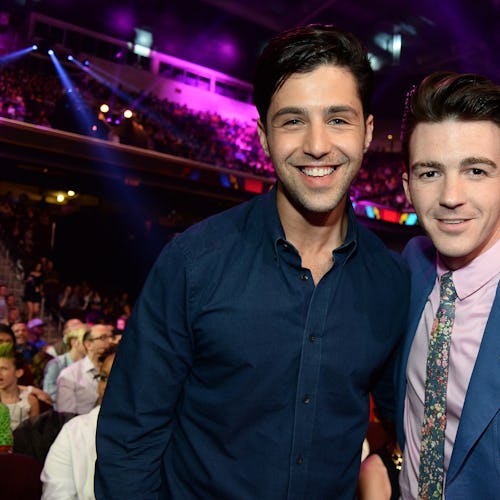 Drake Bell and Josh Peck smile and pose together in the audience at an event center. The former 'Dra...