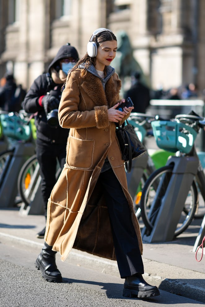 PARIS, FRANCE - MARCH 07: A model wears a white headphones, a white wool pullover, a gray wool hoodi...