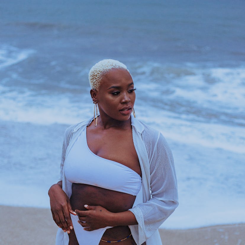 Young woman standing by the ocean, knowing her unlucky zodiac sign will have the worst month of Apri...