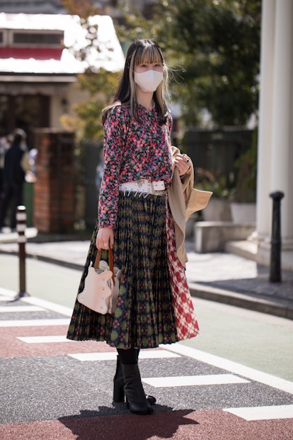 TOKYO, JAPAN - MARCH 19: A guest is seen wearing colorful floral blouse, multi-pattern skirt outside...
