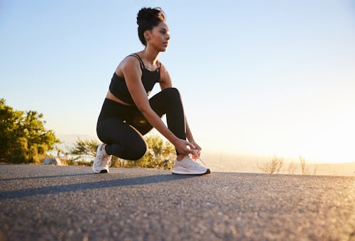 A woman laces up her shoes for a run. These are the most successful zodiac signs.