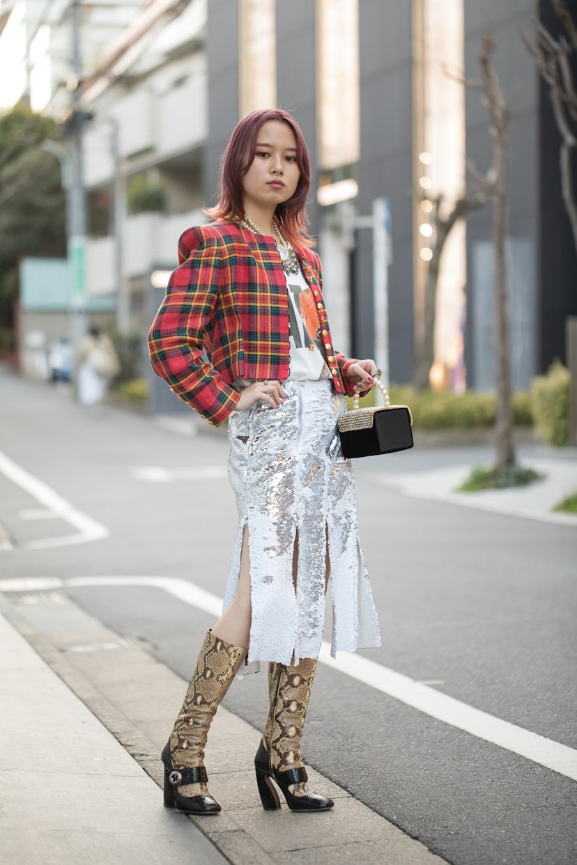 TOKYO, JAPAN - MARCH 15: A guest is see wearing red plaid jacket, silver sequin skirt, knee-high soc...