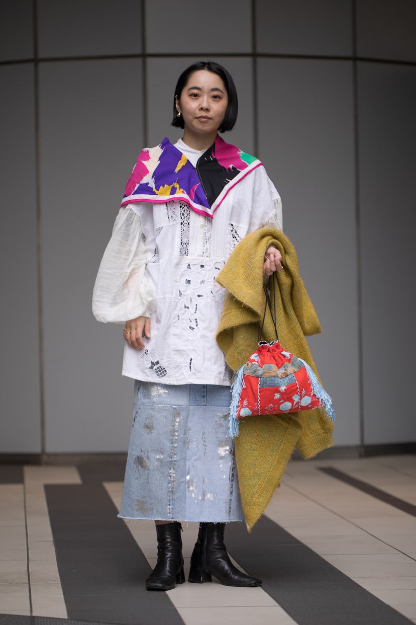 TOKYO, JAPAN - MARCH 17: A guest is seen wearing colorful floral print scarf, white shirt, denim wit...