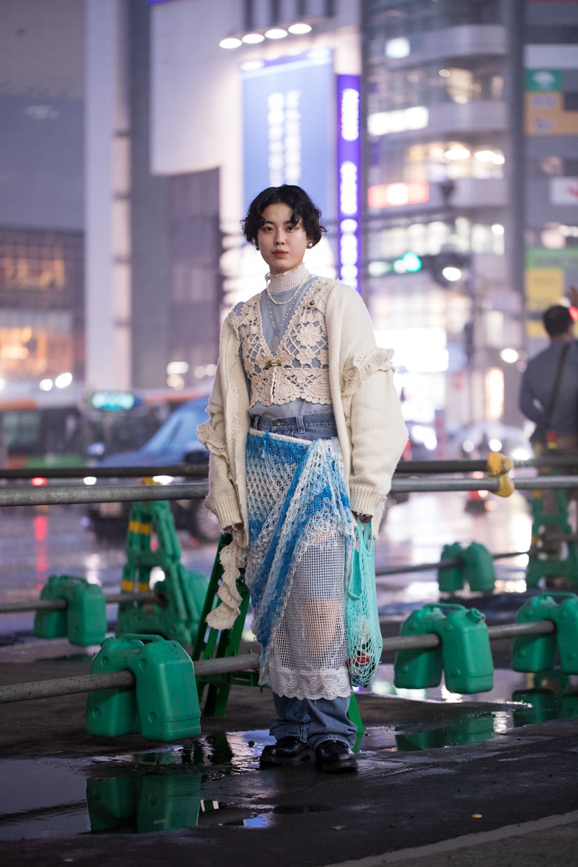 TOKYO, JAPAN - MARCH 19: A guest is seen wearing cream sweater, white lace top, blue shirt, blue kni...