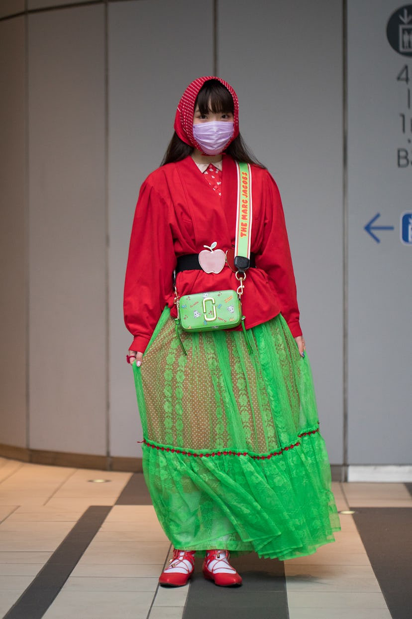 TOKYO, JAPAN - MARCH 18: A guest is seen wearing red and green outfit with apple design belt, green ...