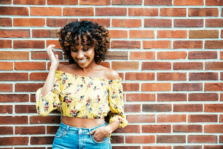 A woman fixes her hair for a photo she'll post to Instagram using hair quotes for a girl as her spri...