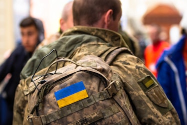 LVIV, LVIV OBLAST, UKRAINE - 2022/03/22: The Ukraine flag on the back of a soldiers backpack. As the...