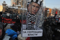 TOPSHOT - Demonstrators carry a carry a model of a prison cell with the cut-out figure of Russia's P...