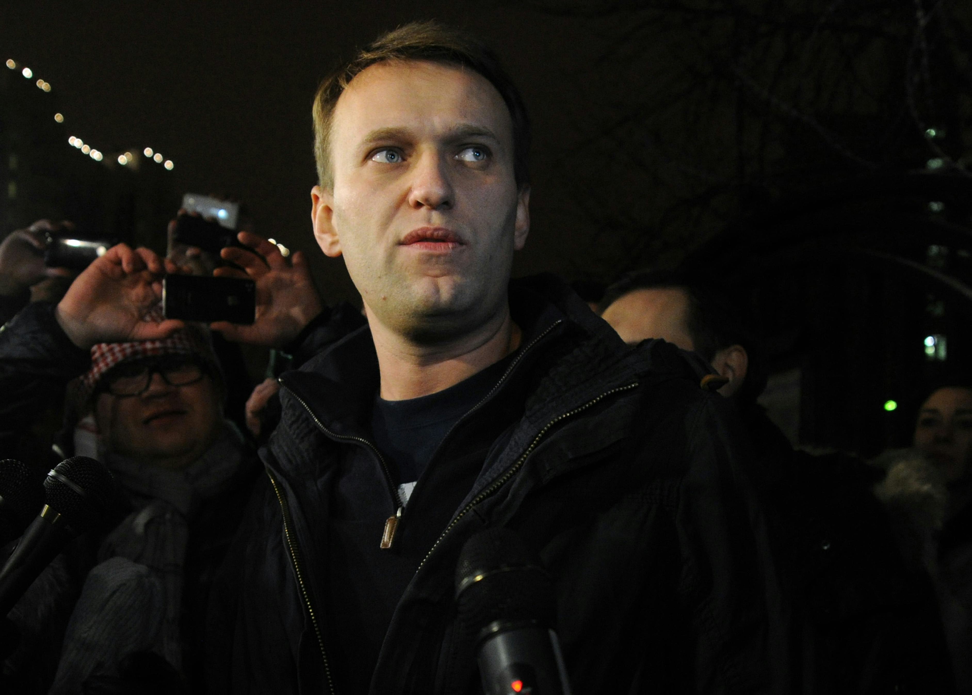 Anti-Kremlin blogger Alexei Navalny speaks to journalists and supporters outside a police station in...