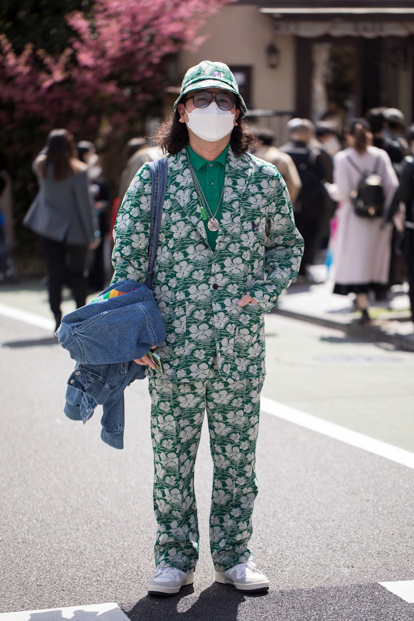 TOKYO, JAPAN - MARCH 19: A guest is seen wearing green/white floral pattern Needles suit and bucket ...