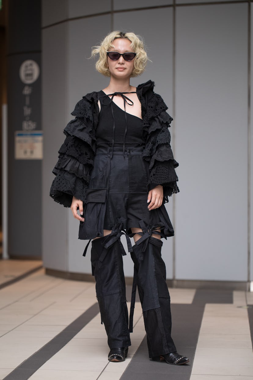 TOKYO, JAPAN - MARCH 17: A guest is seen wearing all black outfit with ruffled top and sunglasses ou...