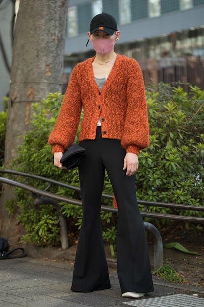 TOKYO, JAPAN - MARCH 15: A guest is seen wearing orange sweater, black cap and pants outside Omotesa...