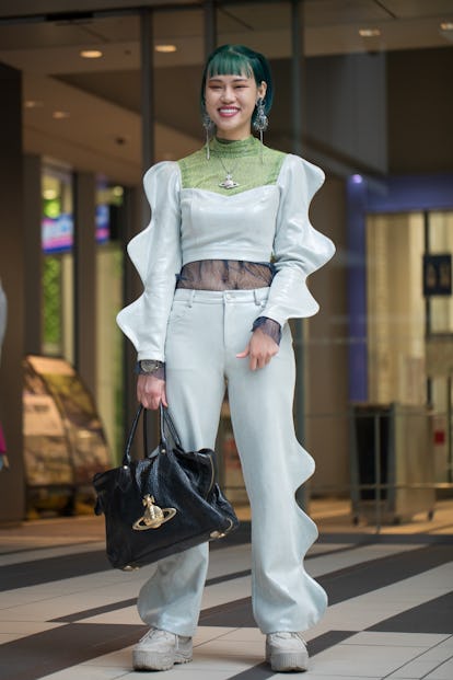 TOKYO, JAPAN - MARCH 18: A guest is seen wearing blue-grey crop top with green and navy lace shirt, ...