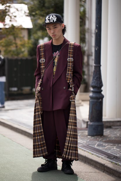 TOKYO, JAPAN - MARCH 19: A guest is seen wearing RequaL≡
hat, maroon blazer, metal T-shirt, plaid pl...