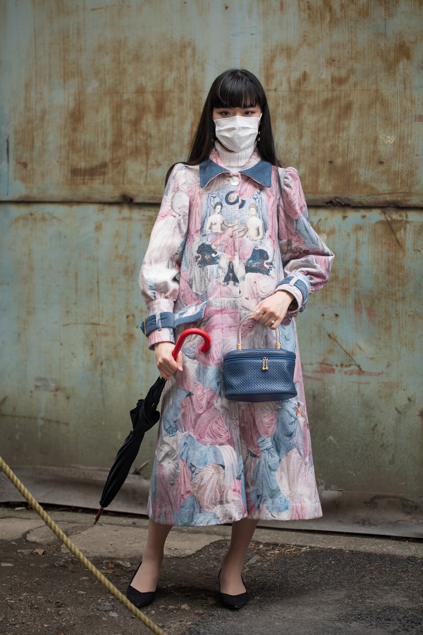 TOKYO, JAPAN - MARCH 19: A guest is seen wearing vintage graphic print pink/blue dress with blue bag...