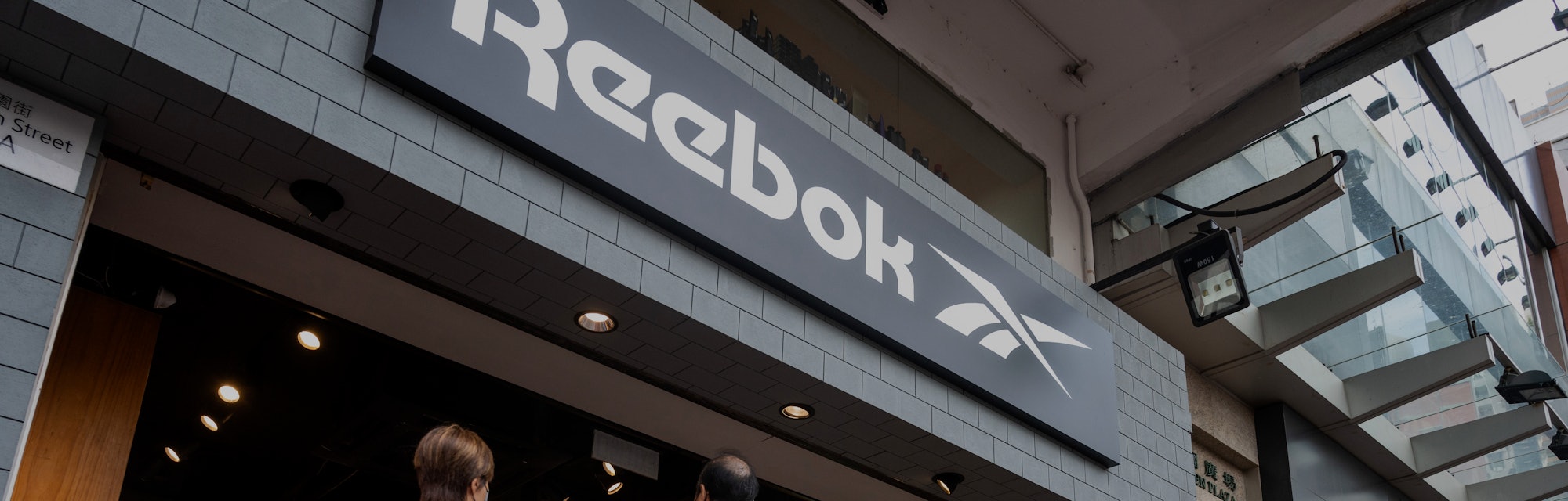 HONG KONG, CHINA - 2021/08/02: Pedestrians walk past the German multinational footwear company brand...