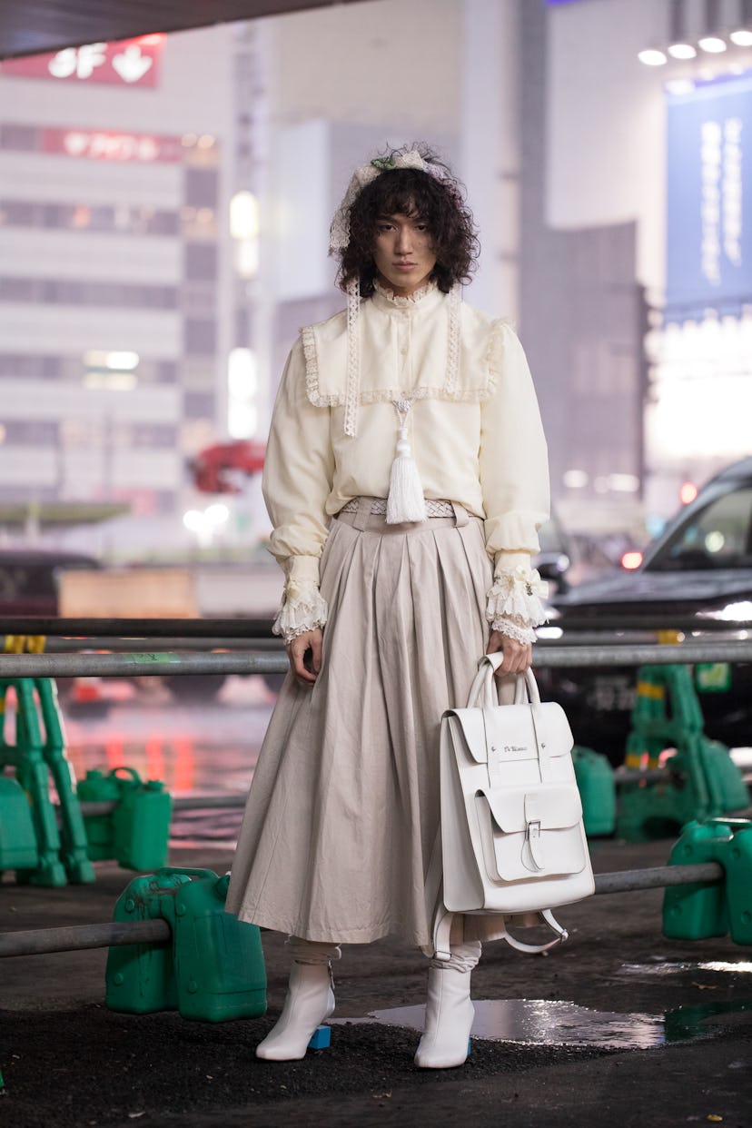 TOKYO, JAPAN - MARCH 19: A guest is seen wearing beige skirt, cream top, white shoes, white leather ...