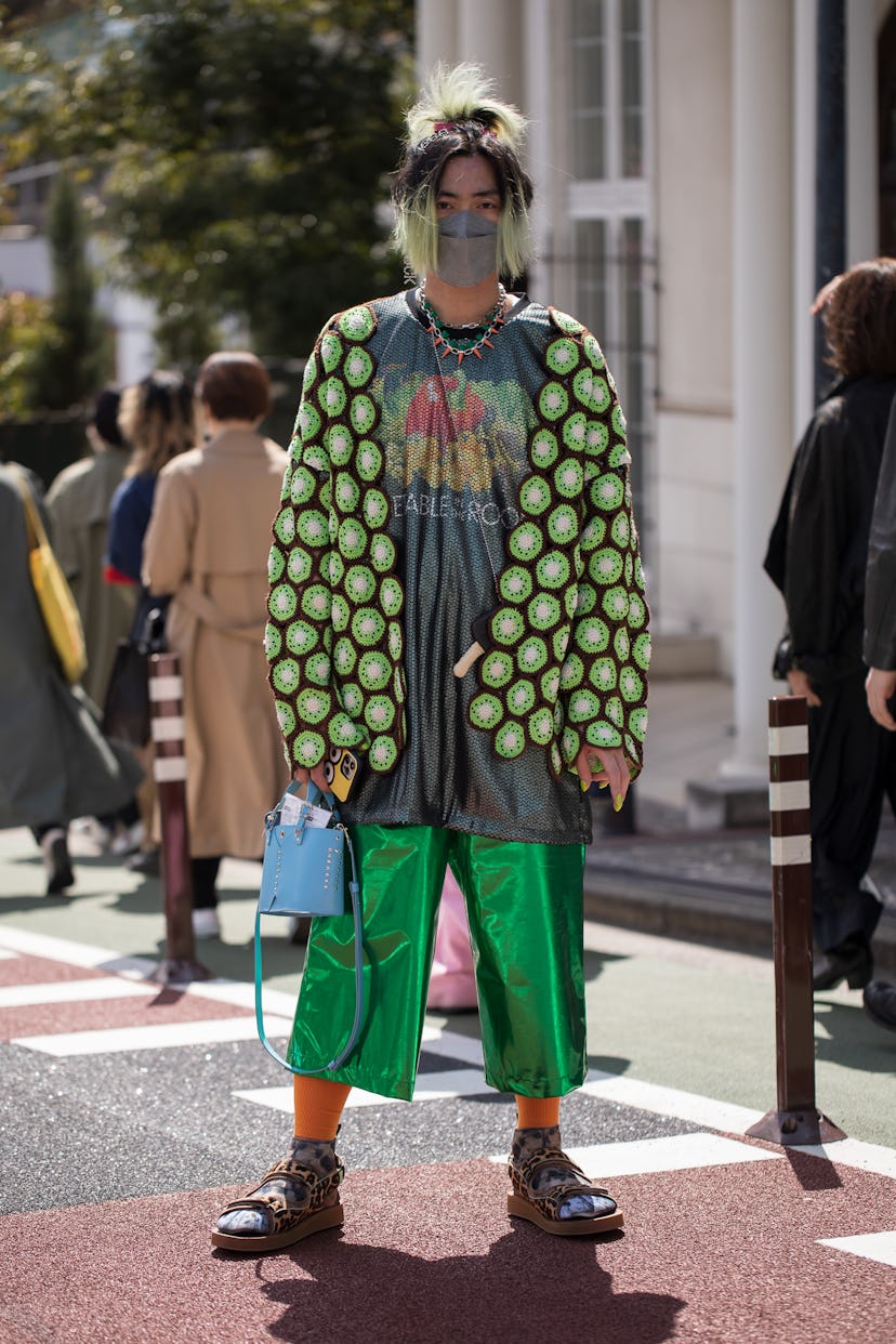 TOKYO, JAPAN - MARCH 19: A guest is seen wearing lime print pattern shirt, metallic green pants outs...