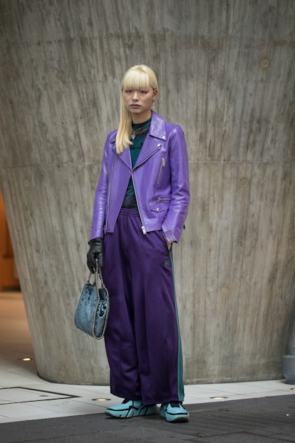TOKYO, JAPAN - MARCH 15: A guest is seen wearing turquoise Prada sneakers, nepenthes purple pants, v...