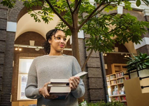 A woman takes books out of an indoor-outdoor library. These are the most intellectual zodiac signs, ...