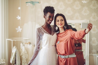 A bride takes a selfie with a bridesmaid, for which she'll need spring wedding quotes.