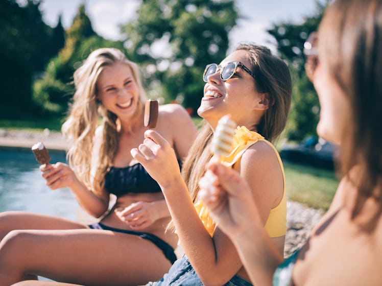 A group of friends sit next to a pool on spring break, thinking of spring break quotes to use for th...