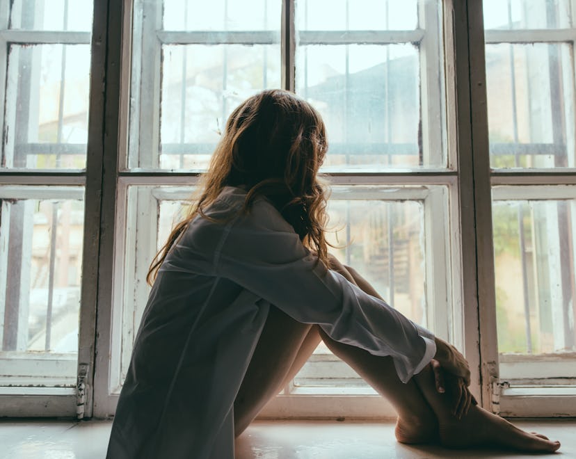 anonymous woman looking out window