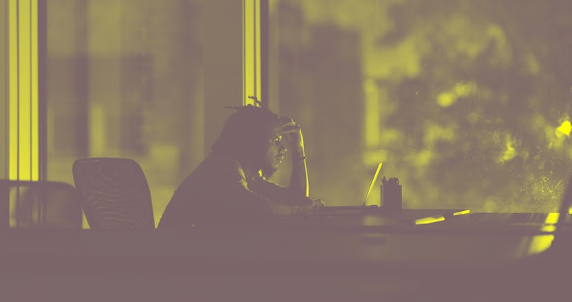 A stressed man works late in his office at night.