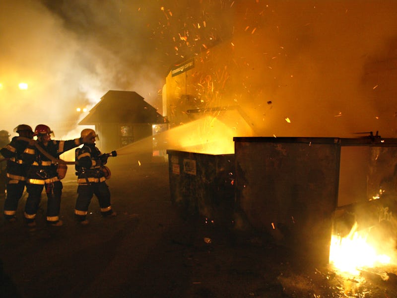 04/12/03 - Dinkytown - Minneapolis firemen put out a fire in a garbage dumpster in a parking lot nex...