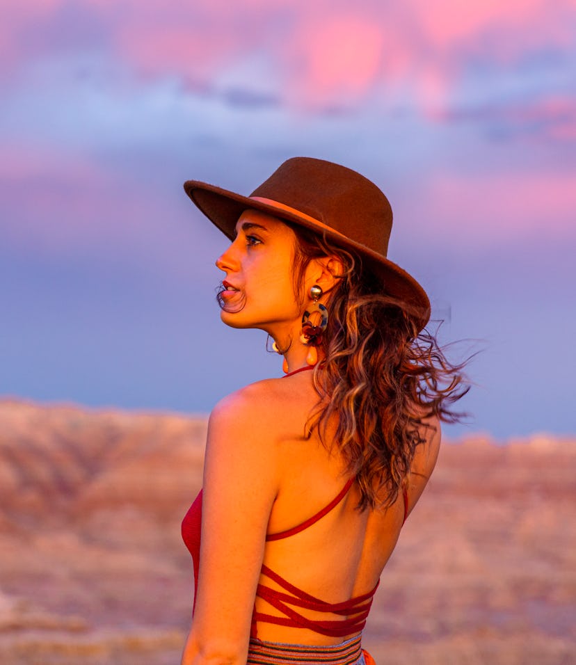 Young woman in the desert during sunset, embracing the spiritual meaning of the April 2022 new moon ...